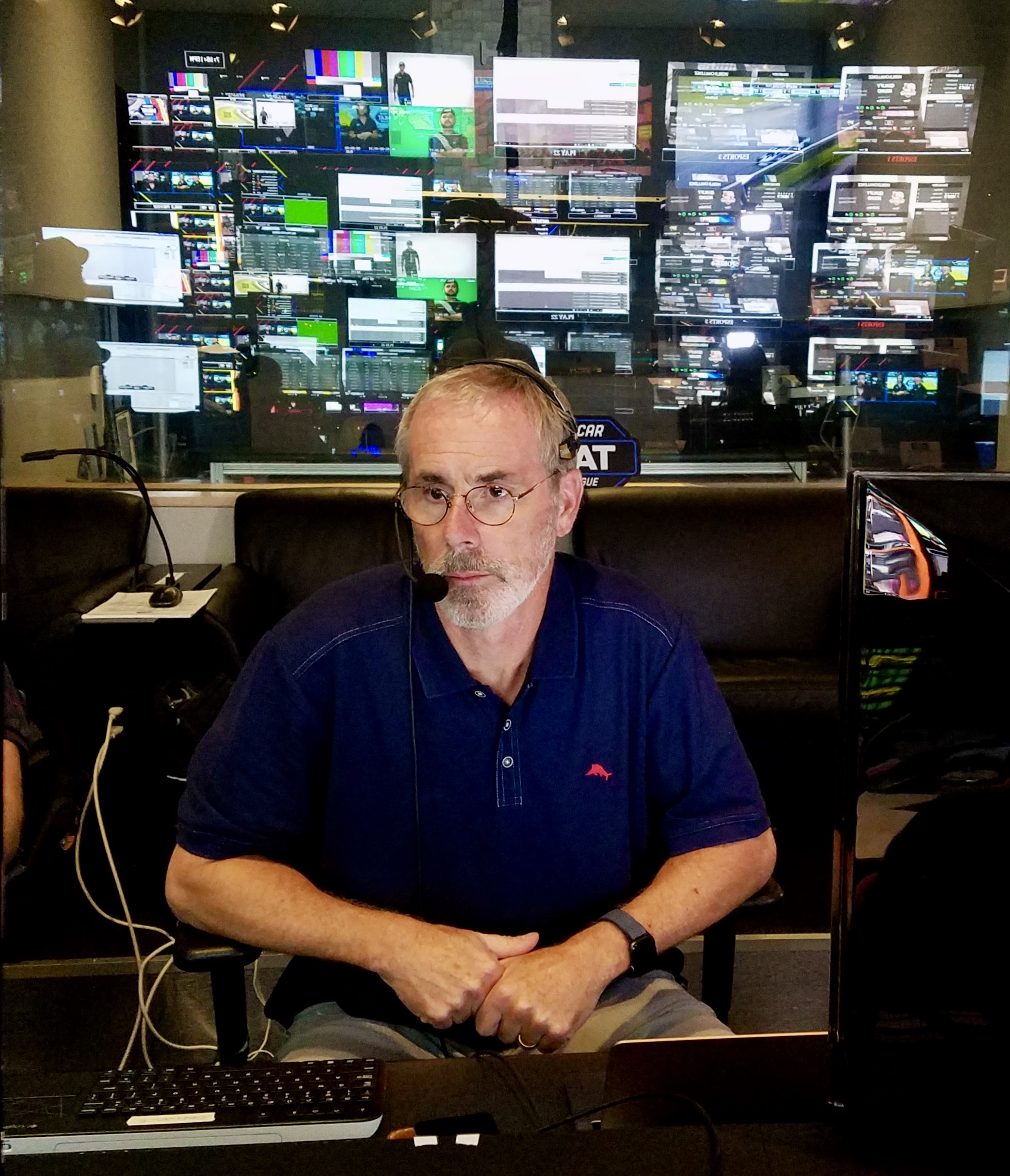 A dizzying amount of screens reflect on the glass in the NASCAR esports control booth.