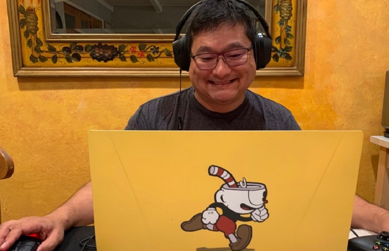 Dean Takahashi plays on a Cuphead-covered Origin PC laptop.
