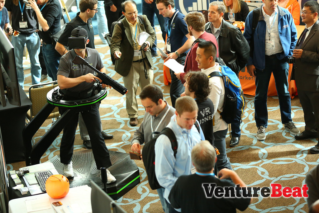 Attendees check out the Omni treadmill controller and Oculus Rift 3D headset at GamesBeat 2013.