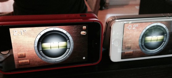Both iPhones are on the same flat surface. The 5S reports 2.1 degrees off, the 5 reports -0.2 degrees off level.