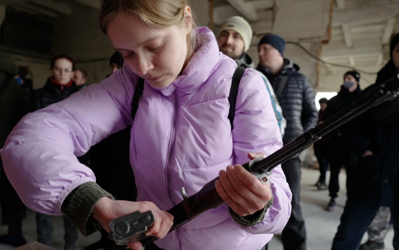A girl loads a gun in Ukraine.
