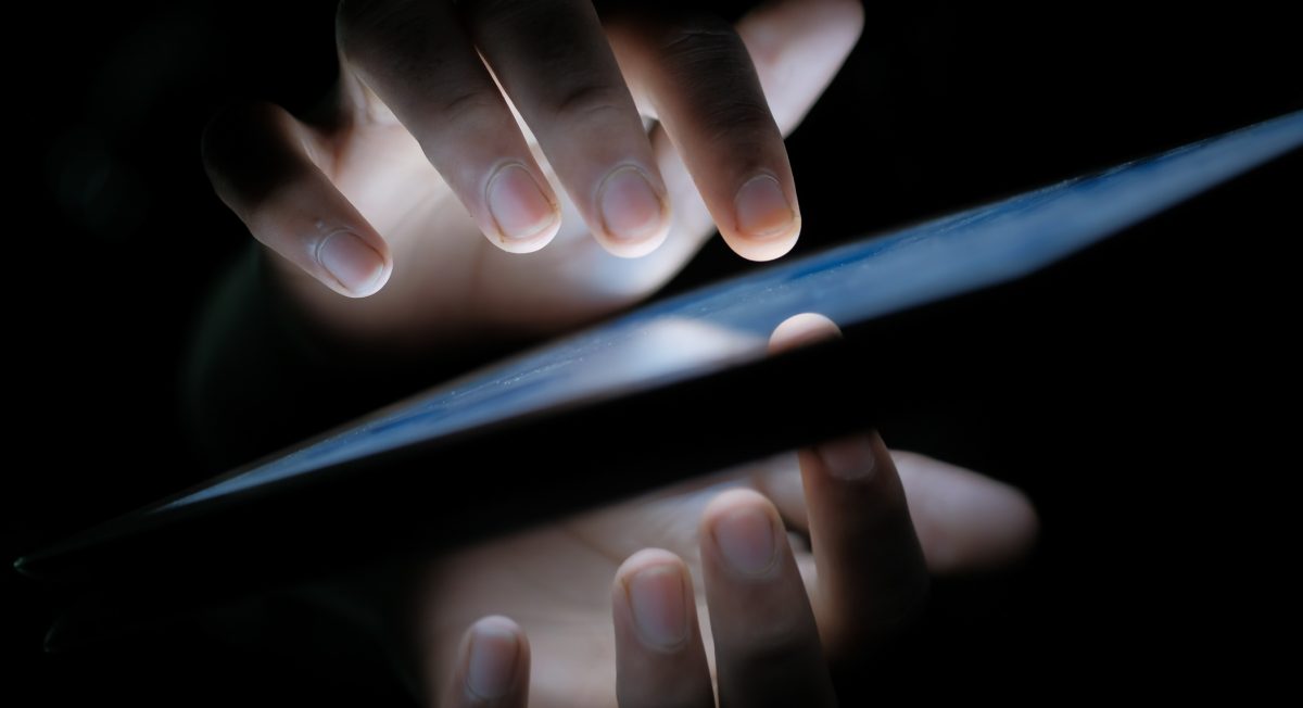 Image of someone tapping on a tablet.