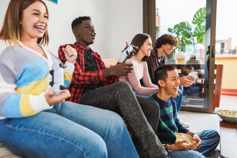 Young friends having fun playing video games at home.