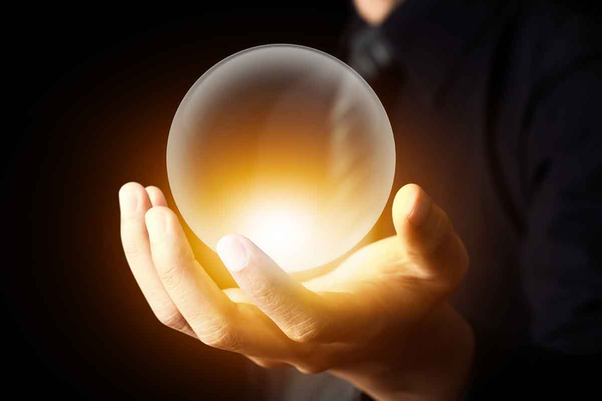 hand holding glowing ball representing prediction, future