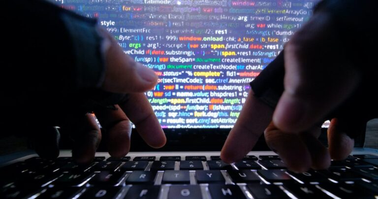 An image of hands typing on a keyboard set against a backdrop of a computer screen.