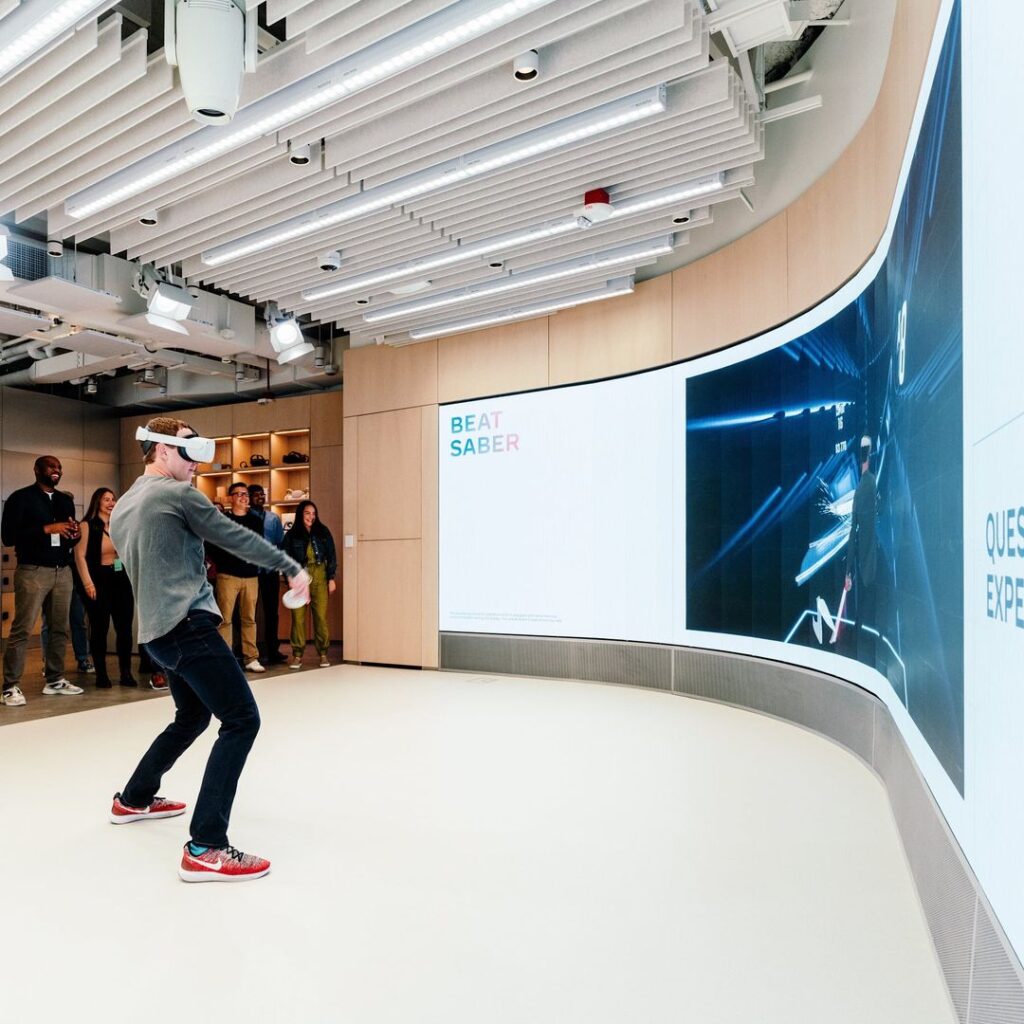 Meta CEO Mark Zuckerberg demos the Oculus Quest 2 before a demo wall that shows what he is seeing.
