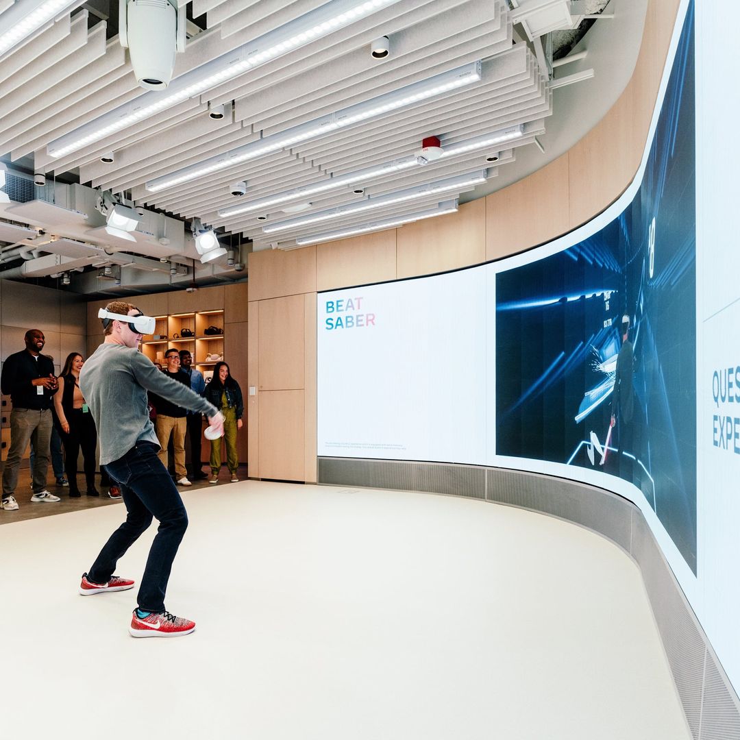 Meta CEO Mark Zuckerberg demos the Oculus Quest 2 before a demo wall that shows what he is seeing.