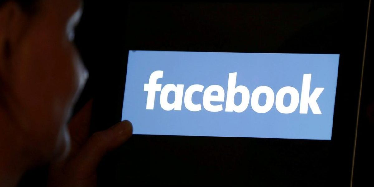 A woman looks at the Facebook logo on an iPad in this photo illustration.