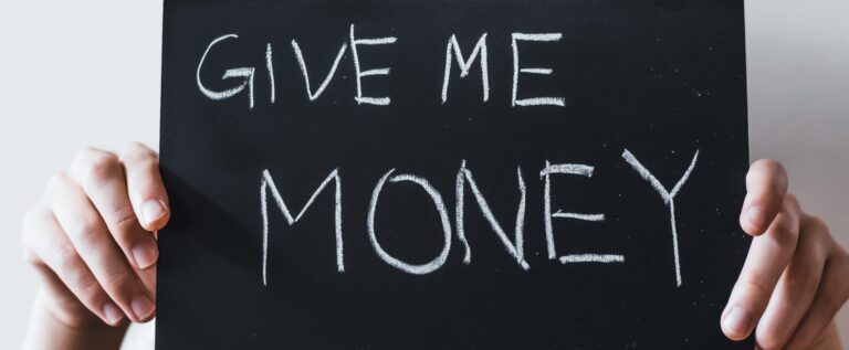 hands holding a sign saying give me money, representing ransomware