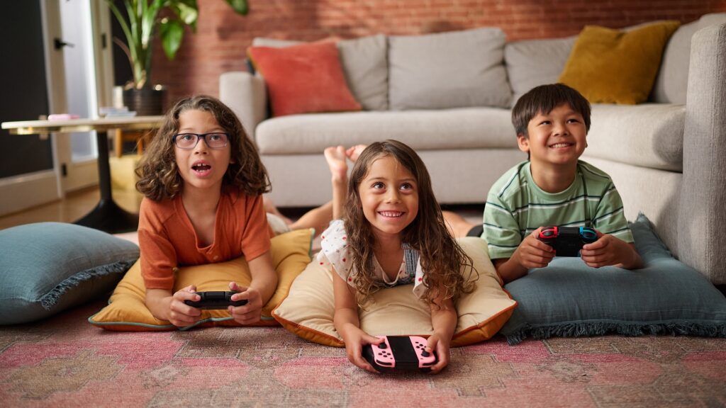 Three young kids playing video games together